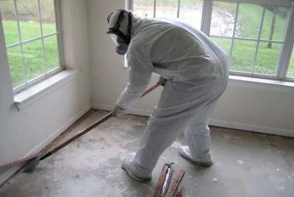 Certified technician in protective coveralls performing meth residue decontamination